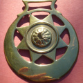 cast star in crescent with insert of stamped flower