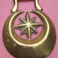 Stamped crescent with 8 point star that has 4 short rays